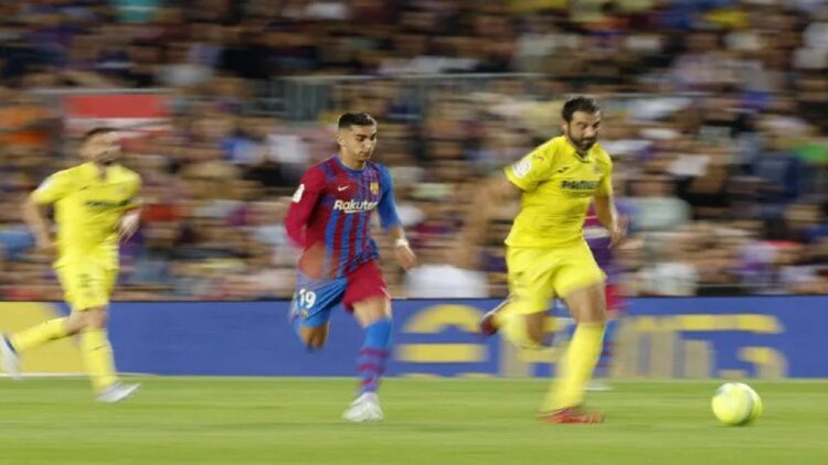 Pemain FC Barcelona Ferran Torres berduel dengan pemain Villarreal Raul Albiol dalam pertandingan terakhir Liga Spanyol antara kedua tim yang dimenangkan Villarreal 2-0 di Camp Nou, Barcelona, Spain, 22 Mei 2022. (REUTERS/ALBERT GEA)
