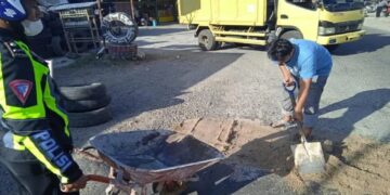 Tak ada Respons dari Pemda, Polisi Bersama Warga Timbun Jalan Berlubang di Simpang Tanjuang Alam Agam