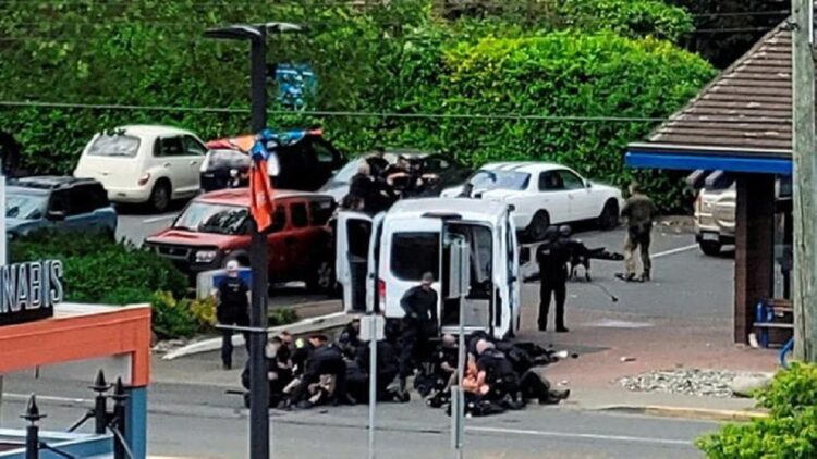 Suasana saat petugas kepolisian berusaha melumpuhkan dua orang bersenjata api di sebuah bank di Saanich, British Columbia, Kanada 28 Juni 2022. (Joan B Flood/via REUTERS)