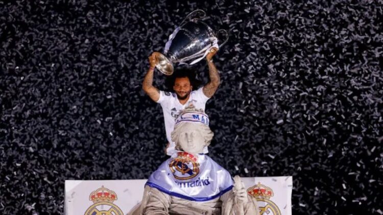 Liga Champions Musim 2022-2023 Dimulai, Ini 26 Tim yang Sudah Peroleh Tiket Fase Grup 1 Pemain Real Madrid Marcelo mengangkat piala Liga Champions diatas air mancur Cybele saat parade kemenangan dengan bus beratap terbuka di Madrid, Spanyol, Minggu (29/5/2022). REUTERS/Marcelo Del Pozo/RWA/djo (REUTERS/MARCELO DEL POZO)
