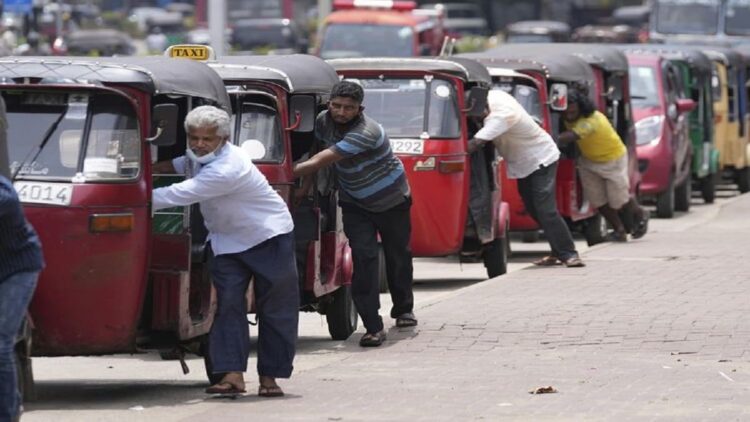 Pengemudi becak motor Sri Lanka mengantre untuk membeli bensin di dekat SPBU ibu kota Colombo, Rabu (13/4/2022). (AP PHOTO/ERANGA JAYAWARDENA)