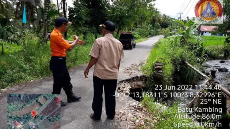 Petugas Satgas BPBD Agam sedang berada di jembatan yang amblas, Kamis (23/6/2022). (Antara/HO-Dok BPBD Agam)