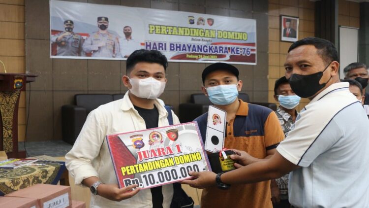Dirintelkam Polda Sumbar Kombes Pol Yanuar Widianto menyerahkan hadiah kepada juara 1 pertandingan domino. (IST)