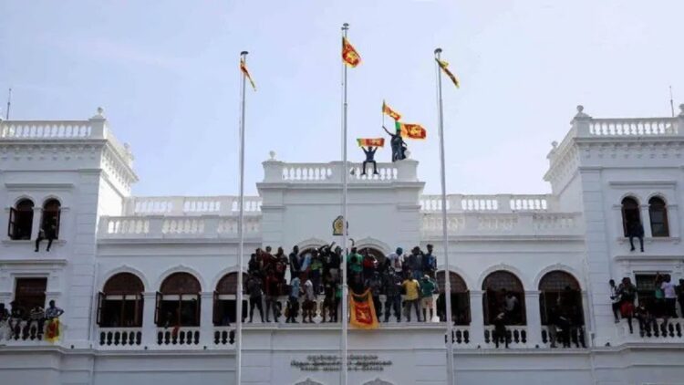 Pengunjuk rasa mengibarkan bendera Sri Lanka di atas gedung Kantor Perdana Menteri Ranil Wickremesinghe di tengah berlanjutnya krisis ekonomi di Kota Kolombo, Sri Lanka, Rabu (13/7/2022). ANTARA FOTO/REUTERS/Adnan Abidi/wsj.