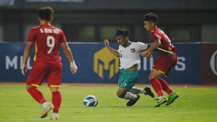Pesepak bola Tim Nasional Indonesia U-19 Arkhan Fikri (tengah) terjatuh saat berebut bola dengan pesepak bola Tim Nasional Vietnam U-19 dalam laga penyisihan Grup A Piala AFF U-19 2022 di Stadion Patriot Candrabhaga, Bekasi, Jawa Barat, Sabtu (2/7/2022). ANTARA FOTO/Aditya Pradana Putra/rwa.(Aditya Pradana Putra)