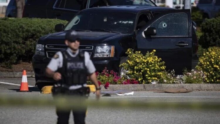 Petugas polisi mengawasi lokasi penembakan di Langley, British Columbia, Kanada, Senin 25 Juli 2022. (Photo : Darryl Dyck/The Canadian Press via AP)
