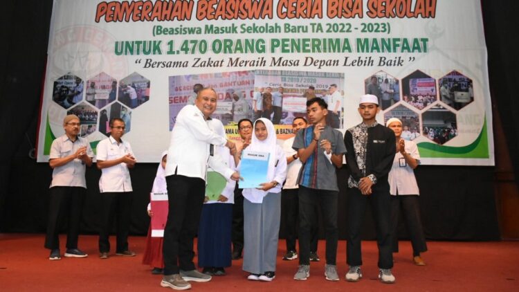 Direktur Keuangan dan Umum PT Semen Padang Oktoweri menyerahkan beasiswa UPZ Baznas PT Semen Padang kepada salah seorang perwakilan pelajar di GSG Semen Padanng, Selasa (19/7/2022).