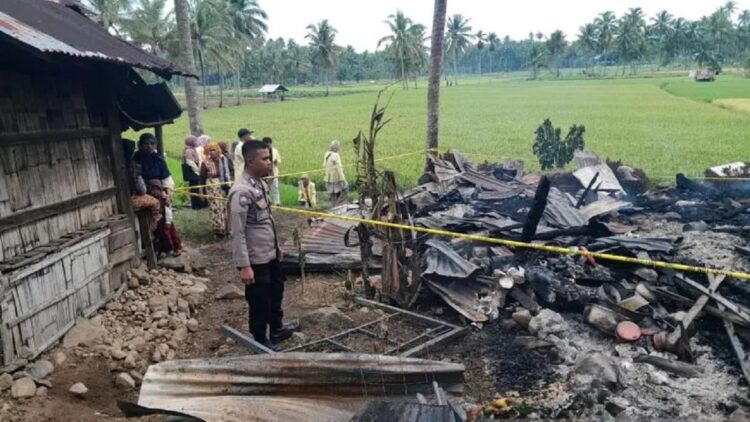 Salah seorang polisi tengah melihat satu unit rumah warga di Nagari Cupak, Kecamatan Kubung, Kabupaten Solok, Sumbar yang ludes terbakar (ANTARA/HO-Humas Polres Solok)