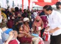 Presiden Jokowi didampingi Ibu Iriana Joko Widodo menyerahkan BMK dan BLT minyak goreng kepada peserta Program Keluarga Harapan (PKH) di Pasar Sungai Duri, Kabupaten Bengkayang, Provinsi Kalimantan Barat, pada Selasa (09/08/2022). (Foto: BPMI Setpres/Kris)