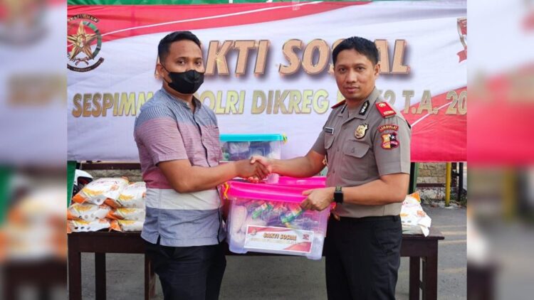 Peduli pada Masyarakat, Kompol Rico Fernanda Bagi-bagi Sembako di Madiun 1 Peserta didik Sespimmen Polri Dikreg ke 62 Tahun 2022, Kompol Rico Fernanda menyerahkan sembako kepada masyarakat. (IST)