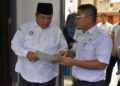 Kepala Dinas Pertanian dan Ketahanan Pangan Kabupaten Padang Pariaman, Sumbar Yurisman Yakub (kanan) menunjukkan sertifikat terdaftarnya varietas kelapa di Kementan ke Bupati Padang Pariaman. ANTARA/HO-DistanKP Padang Pariaman.