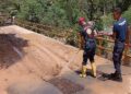 Petugas Damkar Padang membersihkan material longsor yang masih menutupi badan jalan di Sungai Pisang. (IST)
