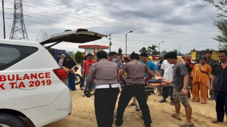 Petugas Kepolisian Polres Dharmasraya dibantu warga mengevakuasi korban ke atas ambulans usai kecelakaan, di Jalan Lintas Sumatera Depan SPBU Putra Mandiri, Nagari Sungai Rumbai, Kabupaten Dharmasraya, Sumbar, Minggu (25/9/2022). (Antara/HO-Satlantas Polres Dharmasraya)