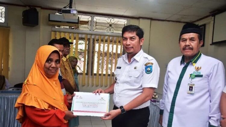 Wali Kota Sawahlunto Deri Asta bersama Ketua BAZNas Edrizon Effendi menyerahkan zakat secara simbolis kepada salah seorang mustahiq di Kecamatan Talawi, Rabu. (Antarasumbar/Yudha Ahada)