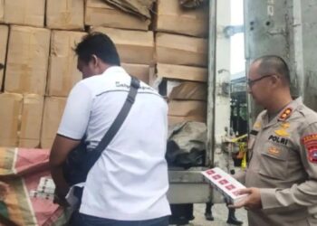 Kapolres Dharmasraya AKBP Nurhadiansyah (dua kanan) dan Kasat Reskrim Iptu Dwi Anggga (kiri) memperlihatkan barang bukti rokok ilegal di Mapolres Dharmasraya, Jumat (2/9). (Antara)