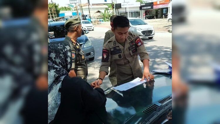 Tim Gabungan di Padang Peringati Pemilik Mobil Toko yang Parkir di Badan Jalan 1 Tim gabungan memberikan surat peringatan kepada pemilik mobil toko yang parkir di badan jalan. (IST)