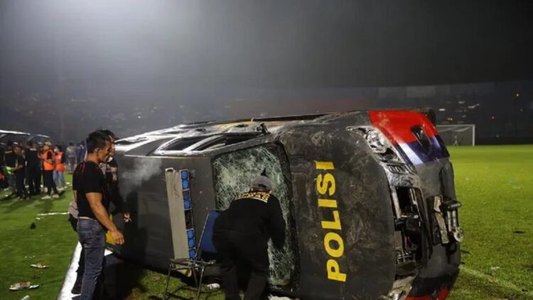 Sebuah mobil polisi terbalik akibat kericuhan usai pertandingan BRI Liga 1 antara Arema melawan Persebaya di Stadion Kanjuruhan, Malang, Jatim, Minggu (2/10/2022). (ANTARA FOTO/H Prabowo/pras)