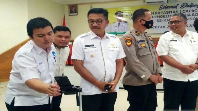 Kepala Dinas Komunikasi dan Informatika Solok Selatan Firdaus Firman menunjukkan PPID berbasis Android kepada Bupati Solok Selatan Khairunas, Kamis (13/10). (ANTARA/Erik IA)
