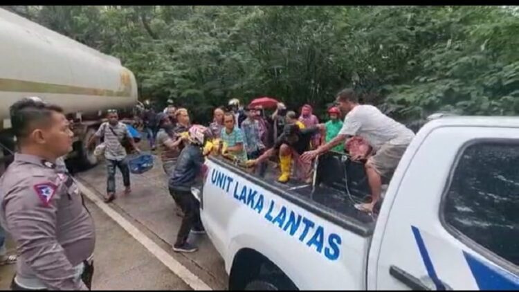 Sopir truk dievakuasi setelah terjepit di dalam truk yang terbalik masuk parit di Sitinjau Luaik. (IST)