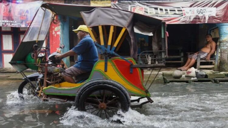 Fenomena Bulan Baru, BMKG Imbau Masyarakat Pesisir Waspadai Banjir Rob 1 Warga melintasi jalanan yang tergenang akibat banjir rob di Bagan Deli, Belawan, Kota Medan, Sumatera Utara, Selasa (25/10/2022). (ANTARA FOTO/FransiscoCarollio)