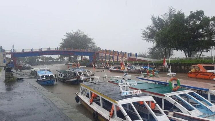 Kapal wisata pulau di Kota Pariaman, Sumatera Barat terlihat hanya disandarkan oleh pemiliknya di muara Sungai Batang Piaman saat hujan mengguyur daerah itu. (ANTARA/Aadiaat M.S.)