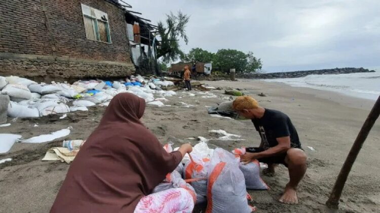 Cuaca Ekstrem Perparah Abrasi Pantai di Padangpariaman, Dapur Rumah Warga Ambruk 1 Warga Pasie Baru, Nagari Pilubang, Kecamatan Sungai Limau, Kabupaten Padang Pariaman, Sumbar sedang mengikat karung yang berisi pasir untuk membantu menahan ombak, Kamis. ANTARA/Aadiaat M. S.