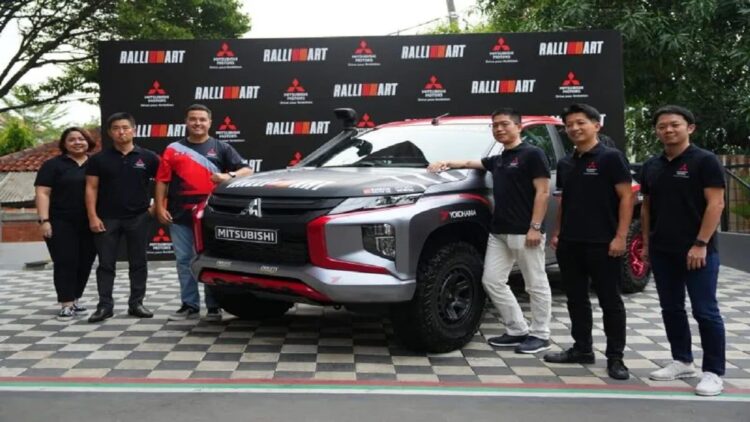 Pebalap Indonesia Rifat Sungkar (ketiga kiri) berpose dengan kendaraan dan tim Mitsubushi Ralliart yang bakal turun pada Asia Cross Country Rally (AXCR) 2022 dari Thailand menuju Kamboja, 21-26 November 2022. ANTARA/HO-Tim Mitsubishi Ralliart