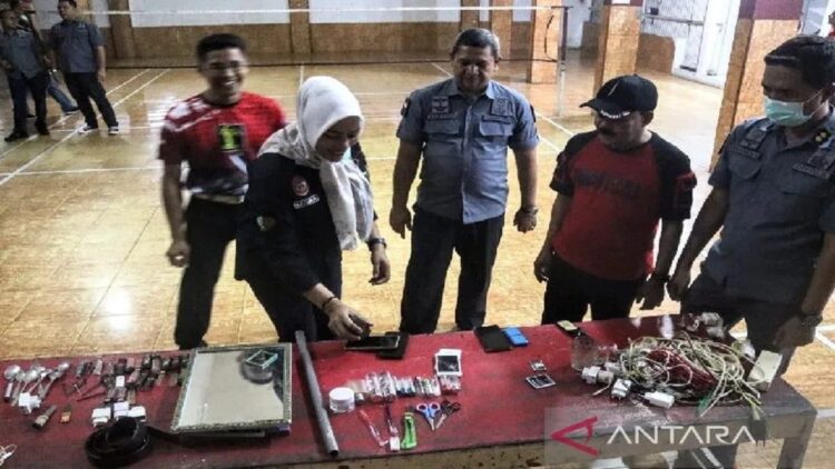 Kepala Divisi Pemasyarakatan Kanwil Kemenkumham Sumbar M Ali Syah Banna (tengah) saat memusnahkan barang sitaan dari kamar warga binaan, di Lapas Padang, Selasa (8/11/2022) malam. ANTARA/FathulAbdi