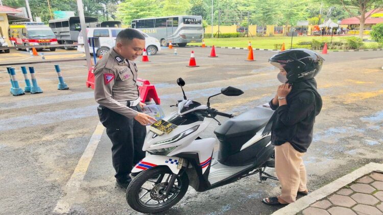 Seorang petugas kepolisian memandu seorang pemohon SIM yang akan melakukan ujian praktik. (Istimewa)
