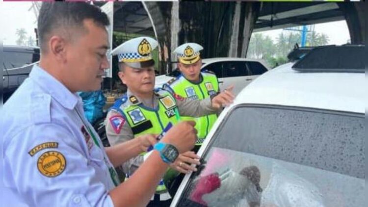 Kasi STNK Ditlantas Polda Sumbar Kompol Angga Putra Kristyadika menempelkan stiker belum bayar pajak kepada pengendara. (Istimewa)