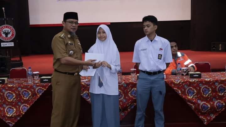 "Senyum Jerapah", Warga Luki Padang Bisa Tukar Sampah dengan Uang 1 Dua orang siswa menerima uang dari hasil program "Senyum Jerapah". (Istimewa)