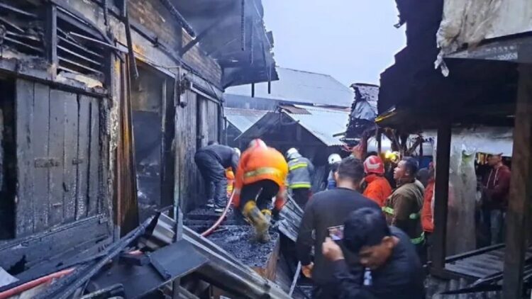 Petugas dan pedagang mengevakuasi sisa barang yang terbakar di Pasar Bawah Kota Bukittinggi (Antara/Alfatah)