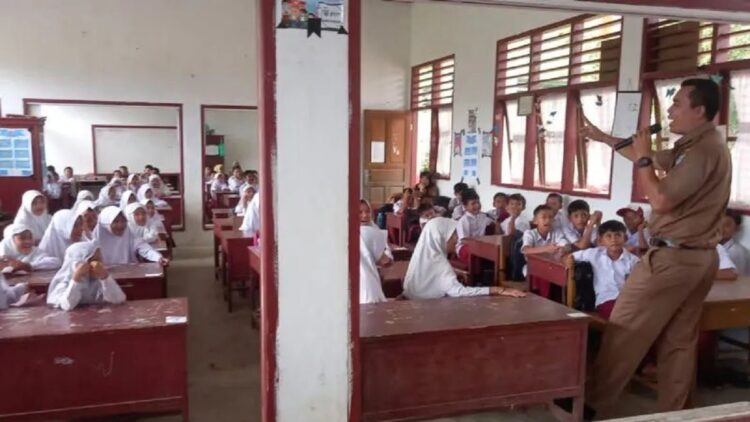 Kepala Bidang Pencegahan dan Kesiapsiagaan BPBD Pasaman Barat Zulkarnain saat simulasi gempa bumi terhadap siswa SD di Kecamatan Talamau, Selasa. (Antara/Altas Maulana)