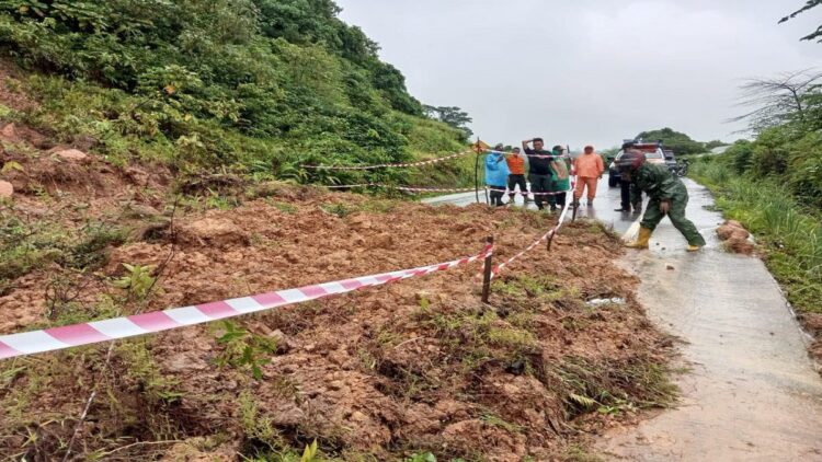Petugas dari BPBD Kota Padang dan unsur kebencanaan membersihkan sisa material longsor yang terjadi di Jalan alternatif dari Air Manis menuju Teluk Bayur. (Foto: Dok. BPBD Kota Padang)