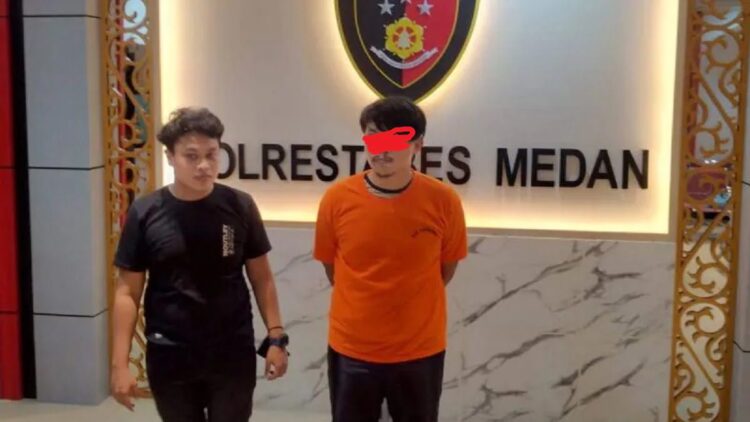 Seorang pria R (kaos merah) pelaku pencurian mobil ditahan di Polrestabes Medan. (ANTARA/HO-Polrestabes Medan)