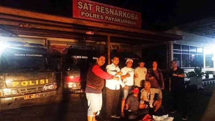 Satres Narkoba Polres Payakumbuh bersama tersangka yang diduga akan mengirimkan narkoba jenis ganja melalui salah satu jasa pengiriman barang. (Antara/HO-Polres Payakumbuh)