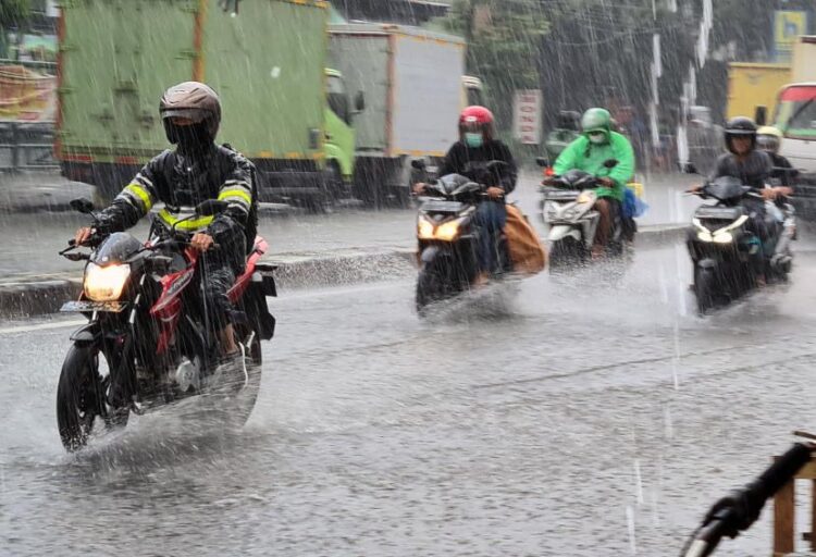 Tiga Hari ke Depan, BMKG Ingatkan Potensi Hujan di Sejumlah Daerah di Sumbar 1 Ilustrasi pengendara motor berkendara di tengah hujan deras. (Foto: Dok. Istimewa)
