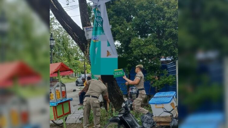Aparat Satpol PP membongkar paksa reklame yang terpasang secara ilegal. (Foto: Dok. Satpol PP Padang)