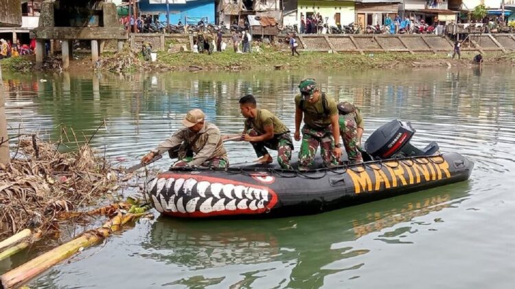 Bersihkan Sampah di Sungai Batang Arau, Yonmarhanlan Padang Kerahkan Personel TNI 1 Prajurit marinir menggunakan perahu karet menyisiri Sungai Batang Arau yang dipenuhi sampah. (Foto: radarsumbar.com/Dok. Diskominfo Padang)
