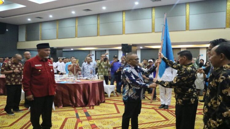 Penyerahan bendera kepada Ketua PWI Sumbar Basril Basyar disaksikan Gubernur Sumbar Mahyeldi. (Foto: Istimewa)