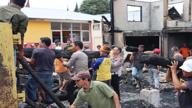 Polisi dan masyarakat bahu-membahu membersihkan puing-puing sisa kebakaran Rumah Gadang di Jorong Balai Tangah, Nagari Cupak, Kecamatan Gunung Talang, Kabupaten Solok. (Foto: radarsumbar.com/Dok. Polres Solok)