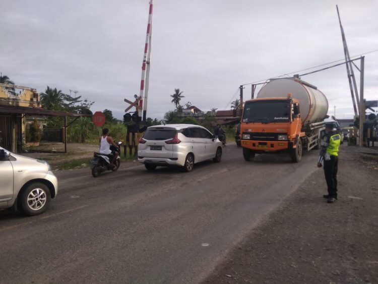 Jalan Berlubang di Dekat Rel KA Pasar Usang bikin Macet, Anggota Lantas Disiagakan 1 Petugas lantas mengatur arus lalu lintas di kawasan dekat rel KA Pasarusang. Kawasan ini selalu padat kendaraan bahkan mengakibatkan kemacetan karena adanya lubang di jalan. (Foto: radarsumbar.com/Herru Iriawan)