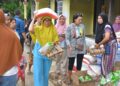 Warga Batu Busuk yang jadi korban banjir, tampak bahagia menerima bantuan paket sembako dari PT Semen Padang. (Dok. Humas)