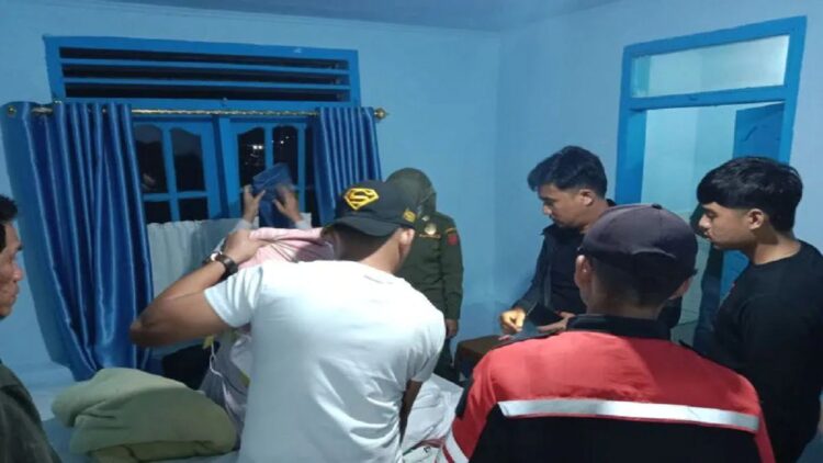 Tim Gabungan Pemkab Agam sedang menggeledah barang milik pengunjung penginapan, Minggu (1/1) dini hari. (Antara/Yusrizal)