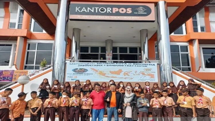 Libatkan Pelajar, Kantor Pos Bukittinggi Giatkan Kebiasaan Menulis dan Berkirim Surat 1 Excecutive Manager Kantor Pos Cabang Bukittinggi, Andesta didampingi Kepala Cabang Pos Biaro, Irvan foto bersama dengan pelajar yang diberikan pengetahuan berkirim surat. (Antara/ Al Fatah)