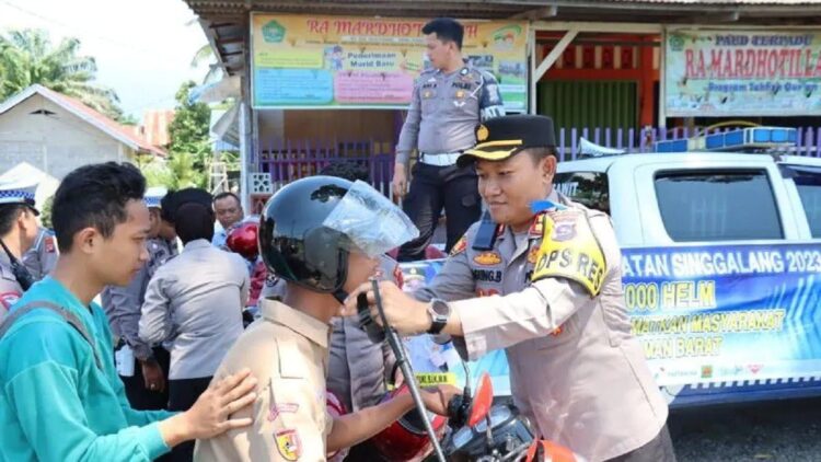 Kepala Polres Pasaman Barat AKBP Agung Basuki saat membagikan helm gratis kepada pengendara dalam Operasi Keselamatan Singgalang 2023 dalam upaya kampanye tertib berlalu lintas. (ANTARA/Altas Maulana)
