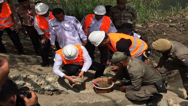 Kurangi Debit Sampah Menuju Muara, Sungai Batang Arau Dipasangi Kubus Apung 1 Wali Kota Padang Hendri Septa meletakan batu pertama tanda pemasangan kubus apung di Sungai Batang Arau, Rabu (15/3/2023). (Foto: Dok. Diskominfo Padang)