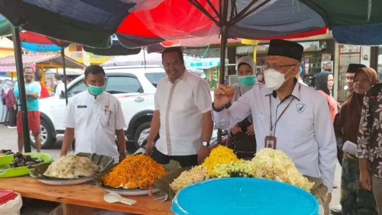 Kepala Dinas Perindustrian Perdagangan Koperasi dan UKM Kota Pariaman, Sumbar Alyendra (kiri) melihat pengambilan sampel takjil oleh Kepala BPOM di Padang, Sumbar Abdul Rahim (kanan) di Pasar Pabukoan di Pariaman pada 2022. (ANTARA/Aadiaat M. S. )