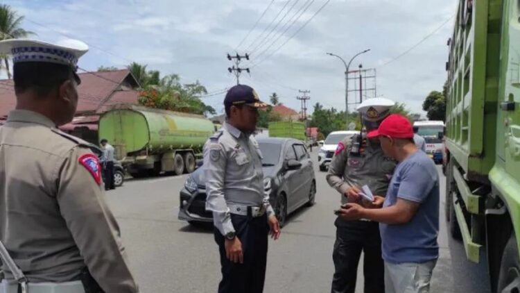 Petugas sedang memeriksa dokumen kendaraan saat Pemeriksaan Kendaraan Bermotor Gabungan Pola Sidang di Tempat di Kota Pariaman, Sumbar pada Senin (13/3). (ANTARA/HO-Diskominfo Pariaman)