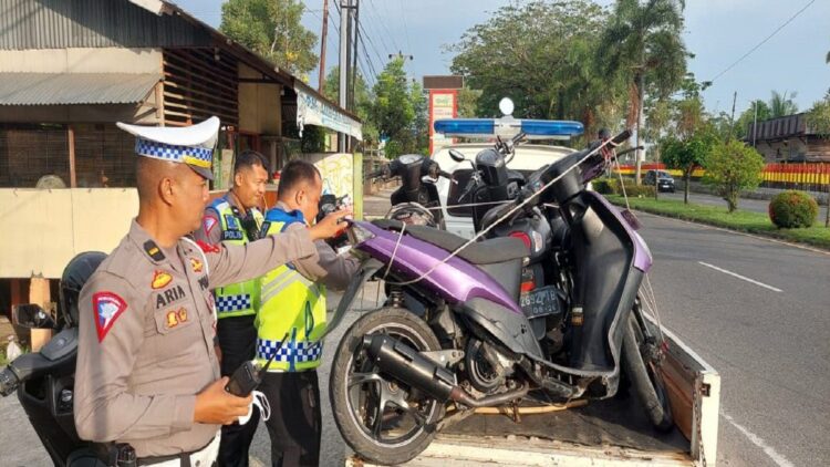 Unit Lantas Polsek Kototangah mengangkut motor yang tak memiliki surat-surat ke atas mobil. (Foto: Dok. Istimewa)